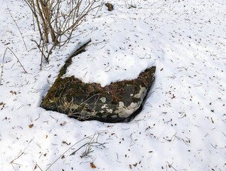 Stone step of the destroyed chapel in the white snow. Ruins of the 17th century. Russia.
