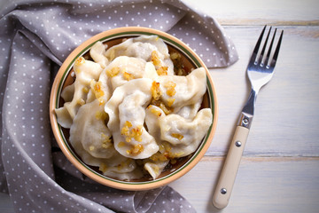Pierogi or pyrohy, varenyky, vareniki, dumplings in bowl on wooden table. horizontal
