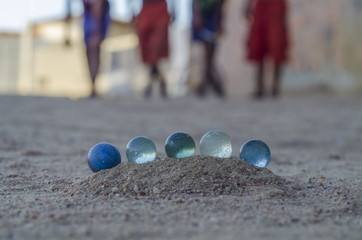 Crian&ccedil;as brincando com bolinhas de gude