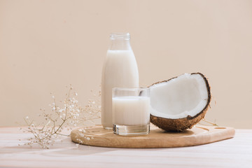 Coconut milk in bottle and glass on table with copy space