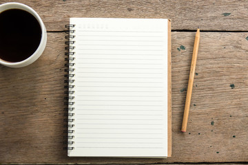 Top view of blank notebook with white coffee and natural light on wooden table.