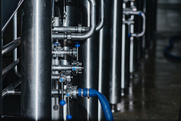 Pipes for giving of malt and water, valves in stainless steel pipes. Clean high quality pipeline in industrial interior