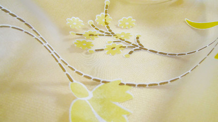 Beautiful light background with yellow flowers made of light fabric.