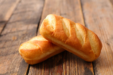 bun, loaf bread on wood background