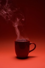 close up view of red cup of coffee isolated on red