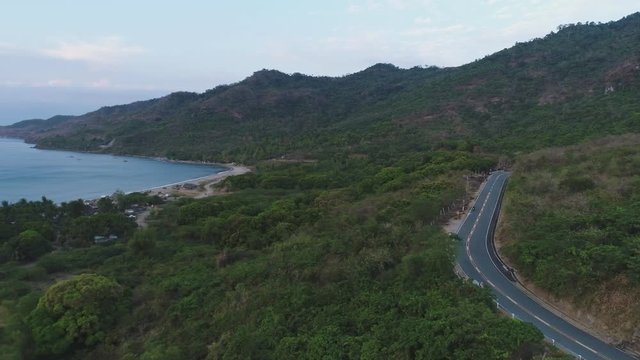  drone shot of a woman passing by on bike near Pico de loro in Philippines