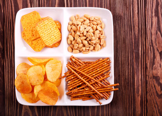 Variety of snacks on plate over wooden table