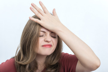 Caucasian young woman with a gloomy, irritated, unhappy face. Face palming