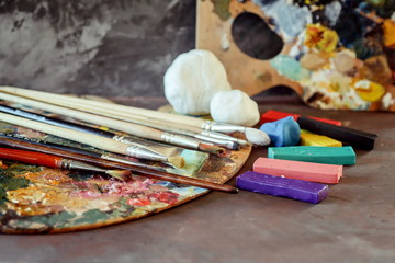 Palette with paints, colored clay and clay for modeling. School of Art. 