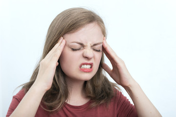 Young caucasian woman because of a headache keeps fingers on temples