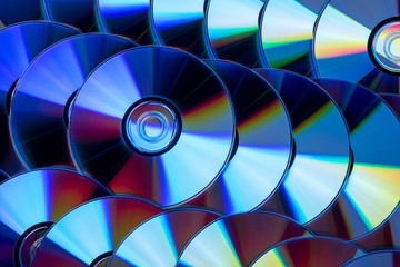 Many musical compact discs with a rainbow spectrum of colors as a bright background