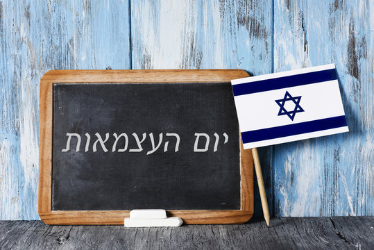 text independence day in hebrew and israeli flag