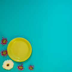 Obraz na płótnie Canvas Summer background - green dish next to purple flowers chrysanthemum
