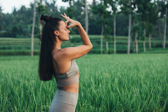 brünette Frau macht Yoga im Reisfeld