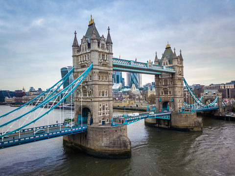 London, England - Aerial view of the iconic Tower Bridge and Tower of London on a cloudy moring with skyscrapers of the financial Bank District at background