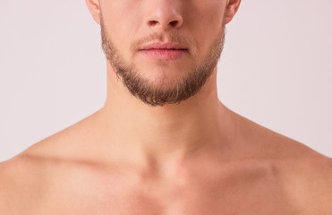 Close up of attractive young man's half face isolated over white background. Portrait of bearded...