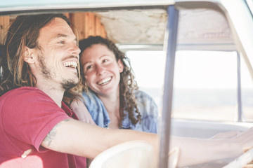 Happy couple inside minivan doing a adventure road trip - Woman with freckles having fun on summer vacation traveling with her boyfriend - Travel, love and holiday concept - Focus on girl face