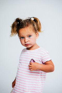 Portrait of a little girl standing against white background