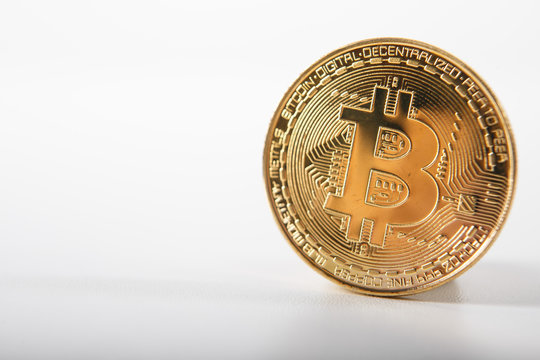 Golden bitcoin on isolated on white table. A visual representation of digital cryptocurrencies. Bitcoin are fully dematerialized and decentralized electronic currencies