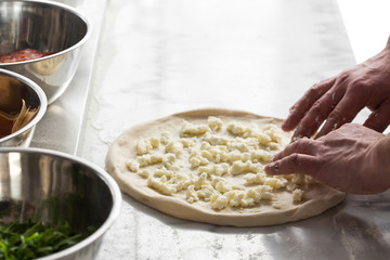 Closeup hand of chef baker making pizza at kitchen.