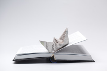 Origami paper boat on a book