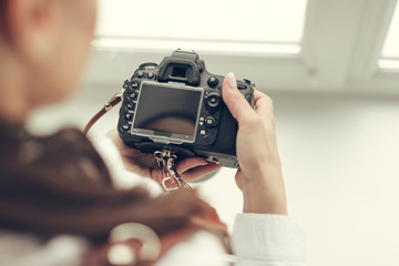 Pretty woman is a professional photographer with dslr camera