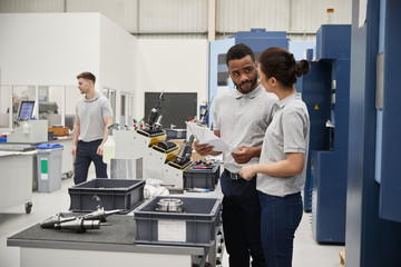 Obraz premium Engineer And Apprentice Meet On Floor Of Engineering Workshop
