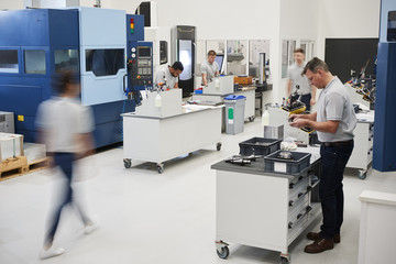Busy Engineering Workshop With Workers Using CNC Machinery
