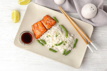 Fish fillet served with rice and green beans on wooden background