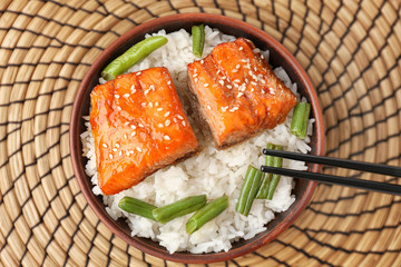 Fish fillet served with rice and green beans on wicker coaster