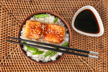 Fish fillet served with rice and green beans on wicker coaster