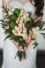 White pink Bridal bouquet with rose buds, eustomas and greenery, selective focuss