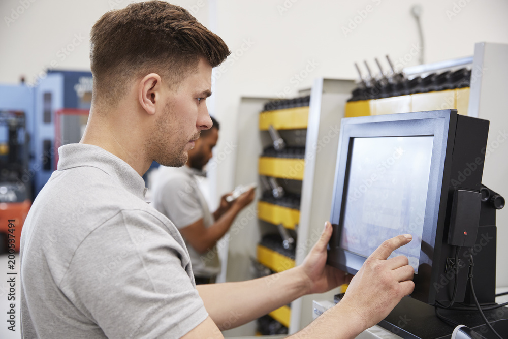 Wall mural engineers selecting tools for use on machinery in factory