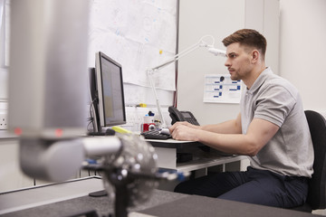 Male Engineer Uses CMM Coordinate Measuring Machine In Factory