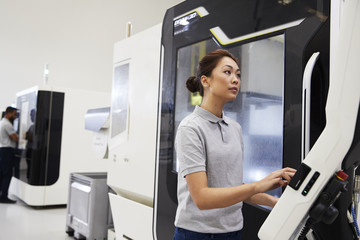 Female Engineer Operating CNC Machinery In Factory