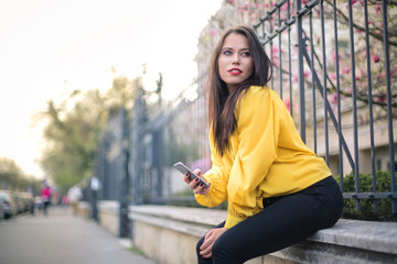 Fototapeta premium Beautiful woman sitting in the street, waiting for someone