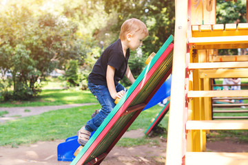 Little kid having fun on outdoor playground. Summer leisure.