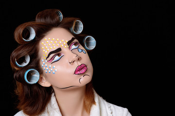 Model with pop art makeup against black background.
