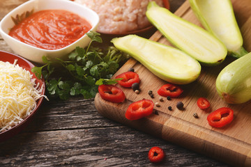 Raw ingredients for baking zucchini, stuffed with minced meat, tomato and cheese.