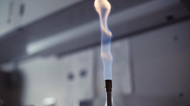 slow motion lighting a bunsen burner in a science laboratory