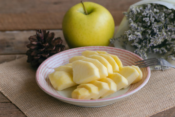 Fresh Shinano gold apple cut and sliced to piece ready to eat on plate put on wood table. Prepare delicious and healthy fruit for snack with family. Sweet sour juicy and crisp apple breed from Japan.