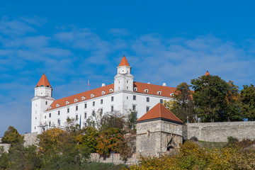 Fototapeta na wymiar Bratislava Castle seen under blue skies with the famous gatehouse, Sigismund's Gate, in the foreground