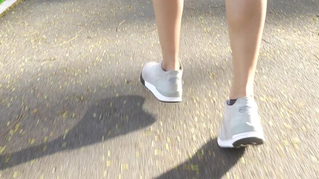 Slow motion - Young asian woman running on sidewalk in morning. Young sport asian woman running in the park. Fitness running sport people and healthy lifestyle concept.