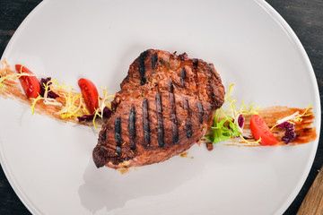 Juicy steak cooked on a grill. Top view. On a wooden background. Copy space.