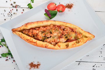 Khachapuri with meat. Georgian cuisine. Top view. On a wooden background. Copy space.