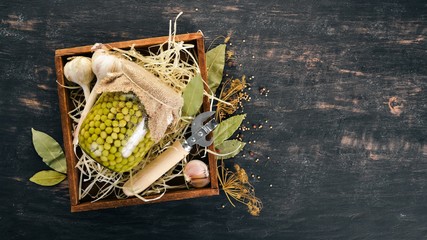 Pickled green peas in a jar. Stocks of food. Top view. On a wooden background. Copy space.