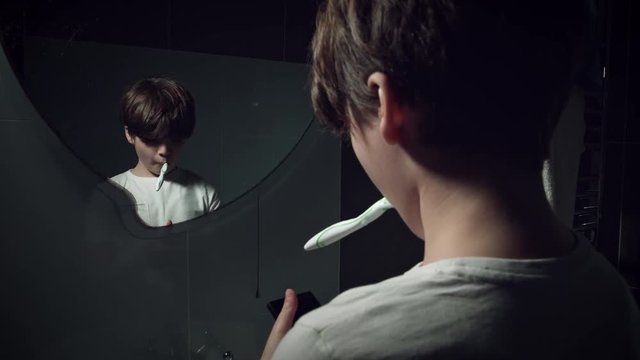 4K Tech-Addicted Child Brushing Teeth with Smartphone