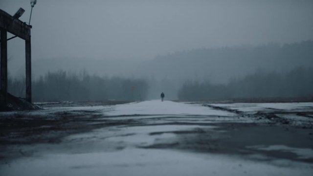 Man walking on an empty road in winter. 