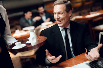 Meeting with chinese businessmen in restaurant. Waiter brings coffee.