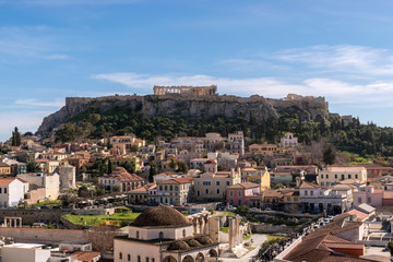 View of Acropolis rock and Monastiraki square at Athens on blue sky background.